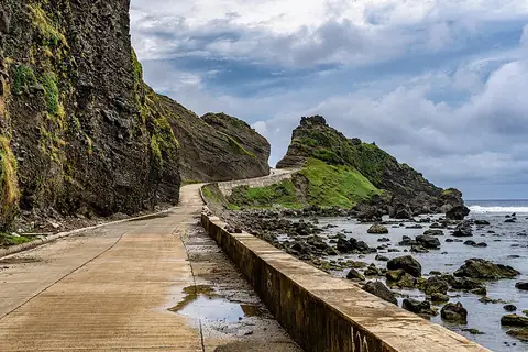 The coastal road climbing toward the Alapad hills and rock formations, Batan Island