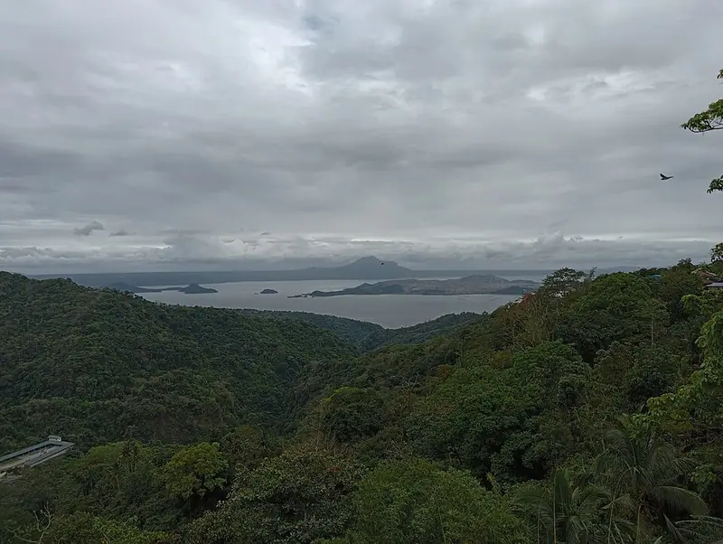 Taal Lake and Volcano Island under clouds, seen from the forested caldera rim