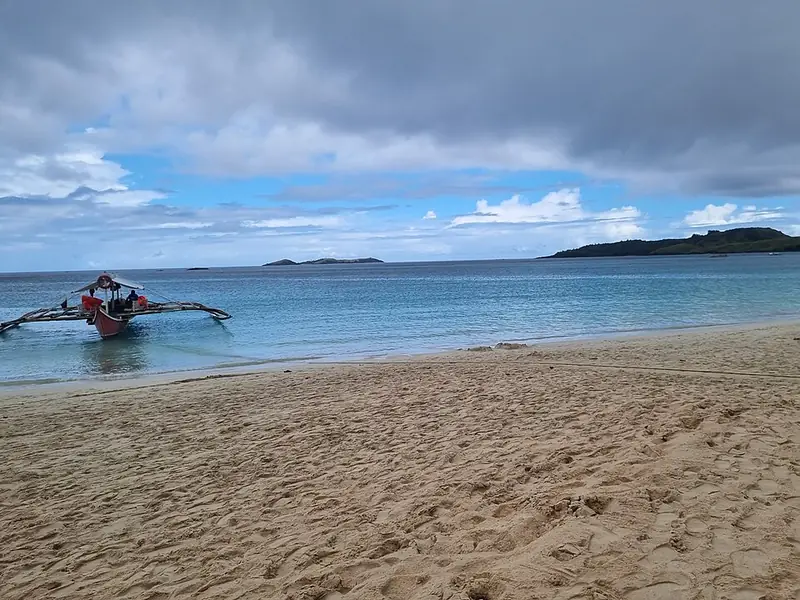An outrigger boat off a white-sand beach on the Calaguas Islands