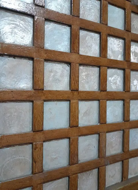 Close-up of a window with translucent capiz-shell panes in a wooden grid