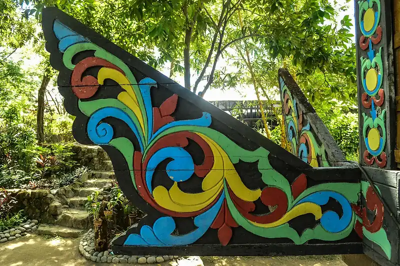 A carved and painted panolong, the okir-decorated beam end of a torogan