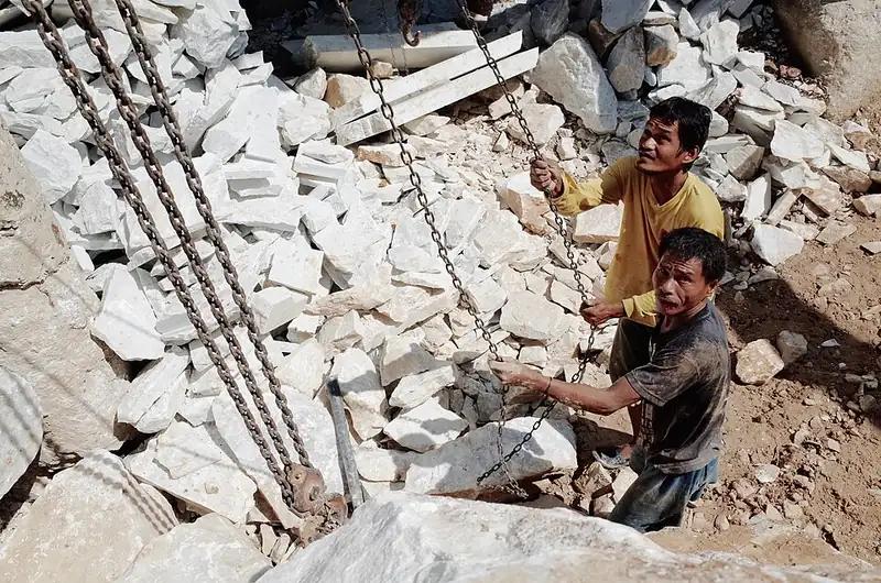 Workers moving blocks of white marble at a Romblon marble plant